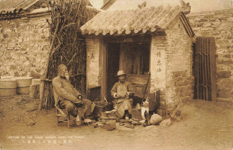 Early 1900s Japanese real photo postcard entitled Picture of the Shose Mender Aside the Street.   Shoe mender?