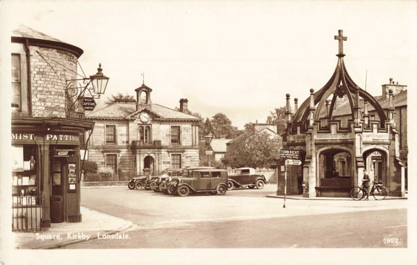 Old real photo postcard of The Square, Kirkby Lonsdale showing old cars