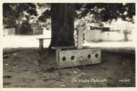 Old real photo postcard of The Stocks, Meldreth in Cambridgeshire