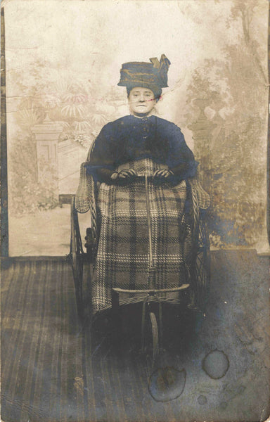 Old real photo postcard of lady in motorised? wheelchair