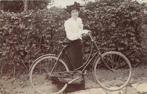 Old real photo postcard of a lady with her bicycle