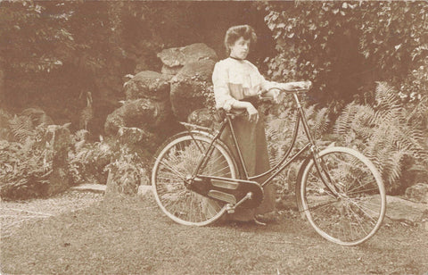 Old real photo postcard of a lady with her bicycle